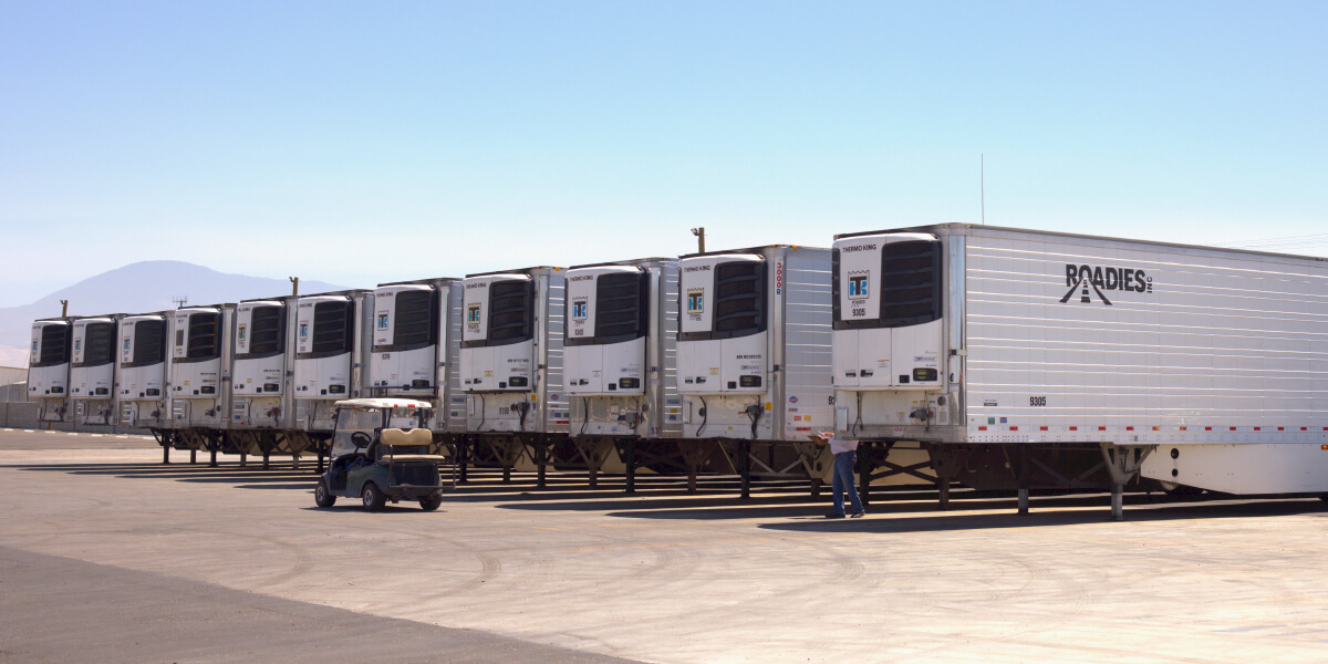 Trailer shipping process with trucks loading and moving freight in Bakersfield