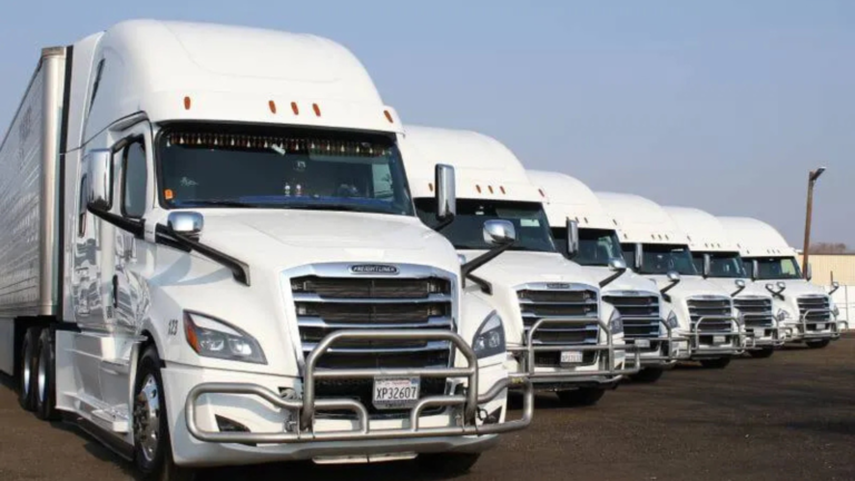 Business leader shaking hands with a logistics partner beside a truck and warehouse, symbolizing strategic shipping partnership